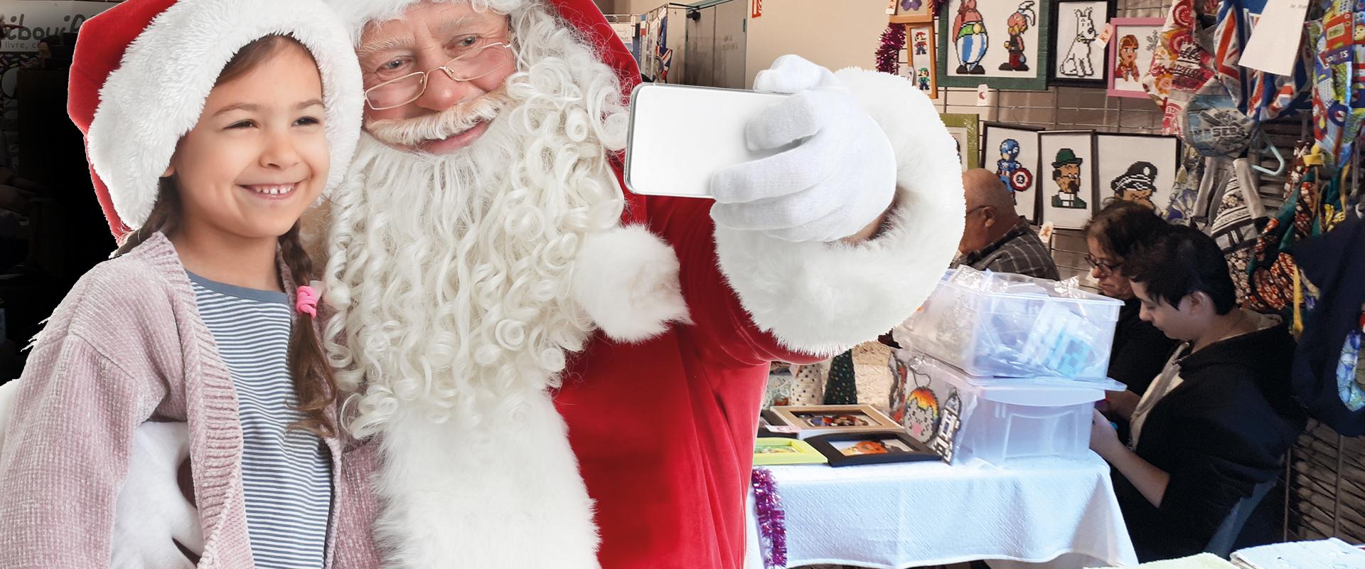 Père-Noël prenant une photo avec une petite fille